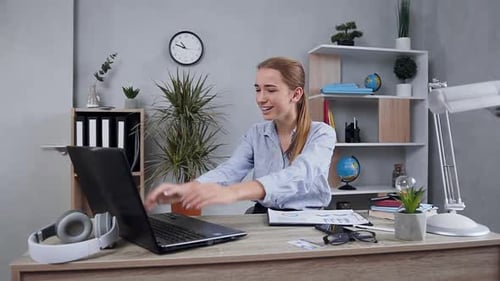 Excited Woman Celebrating Success at Office Desk
