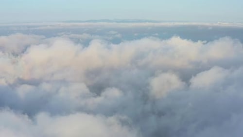 The Drone Rises From the Thick Fog Over the Beautiful Ocean of Clouds at Dawn