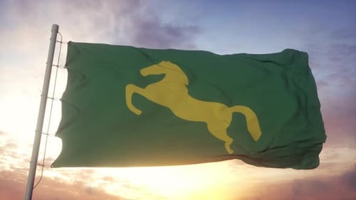 Green Flag with Yellow Horse Emblem Waving at Sunset