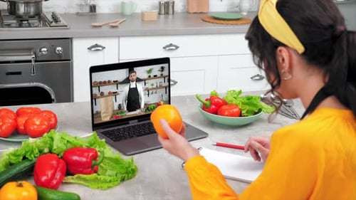 Woman Takes Online Cooking Class in Modern Kitchen