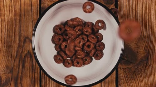 Chocolate Cereal Rings Filling Up White Bowl