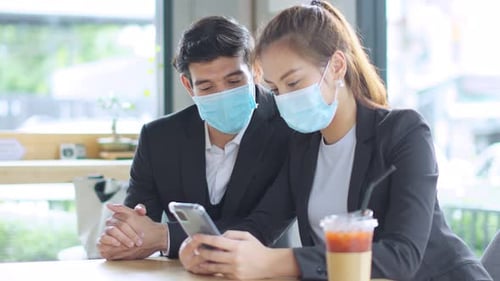 Young Adults Using Cell Phone in Masks Indoors