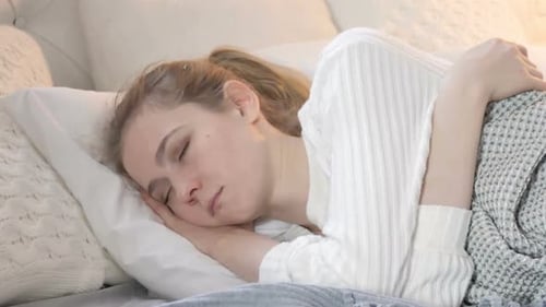 Young Adult Woman Sleeping Peacefully in Bed