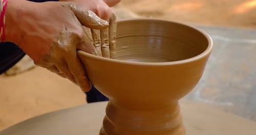 Des mains habiles de potier façonnent l'argile sur Potter Wheel et sculptent un pot en argile. Shipagramme