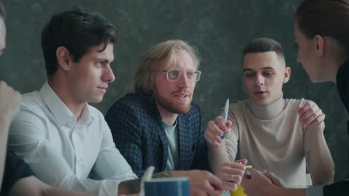 Coworkers Collaborating Around Table in Urban Workplace