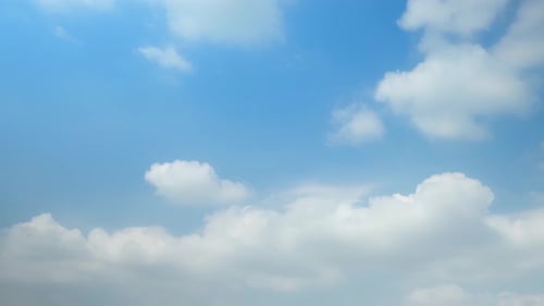 Clouds float across a clear blue sky