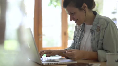 Woman Completes Successful Online Transaction on Laptop