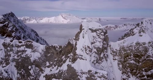 Vue aérienne par Drone d'un skieur skiant sur une montagne escarpée recouverte de neige.