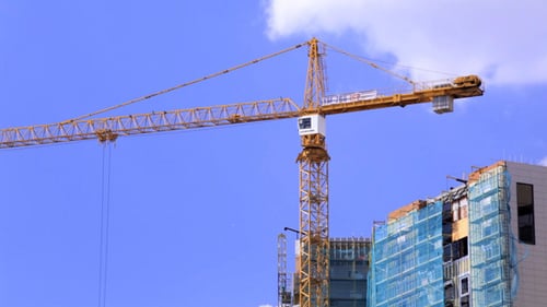 Modern Building Construction with Crane on Bright Day