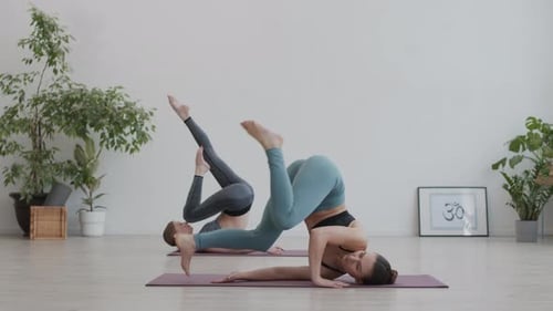 Women Perform Headstand Yoga Pose Indoors