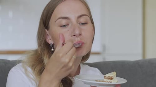 Woman Eating Cake With a Spoon at Home