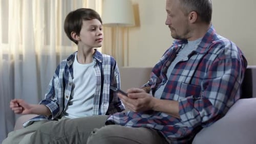 Papa gibt dem Sohn Geld aus der Brieftasche für neues Spielzeug, Kindertaschengeld, Finanzen