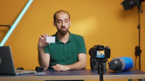 Man Demonstrating Memory Card at a Desk