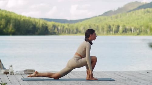 Femme en forme pratiquant le yoga sur Lake Pier