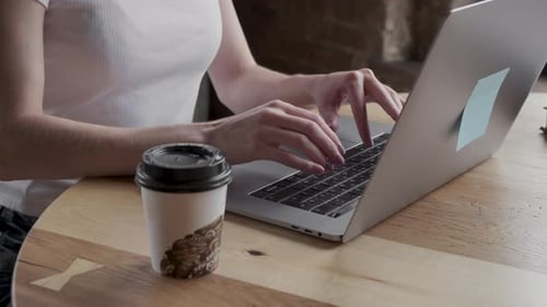 Closeup of a female hands busy typing on a laptop. Woman's hands pressing keys on a laptop
