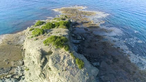 Aerial Top View of Cliff Rocks in a Blue Sea