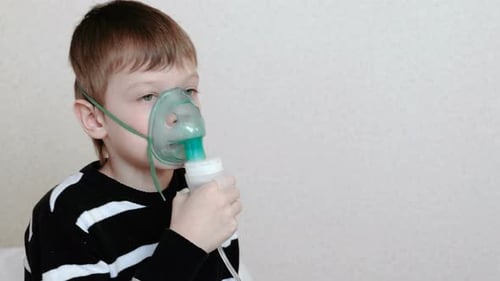 Child Uses Nebulizer with Medical Mask