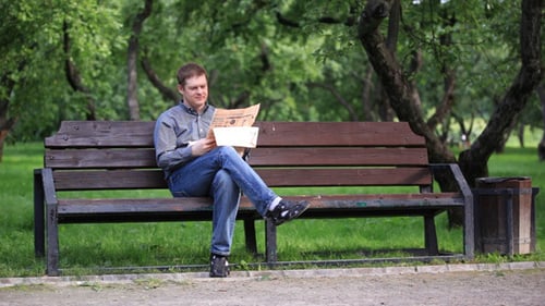Man Reads Newspaper On Bench In The Park 1