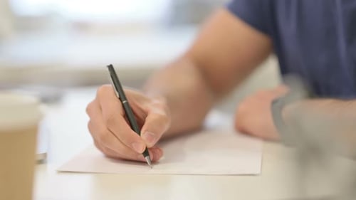 Nahaufnahme männlicher Hände, die auf Papier schreiben