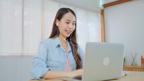 Young Adult Working at Computer with Headphones