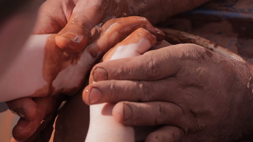 Hands Guide Clay on Pottery Wheel Close Up