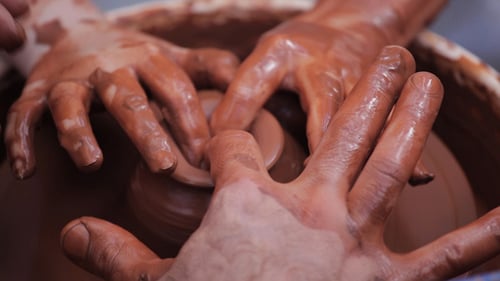 Hands Forming Clay on Pottery Wheel Close Up