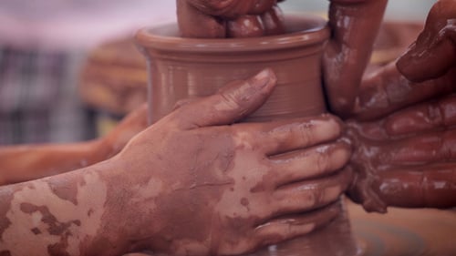 Hands Shaping Clay into Pottery on Wheel