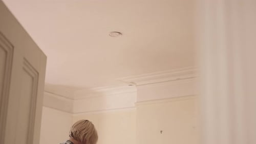 Woman Testing Smoke Detector in Home