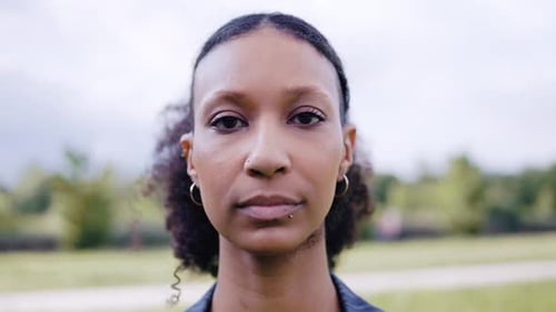 Authentic Latin young woman looking at camera outdoor in city park