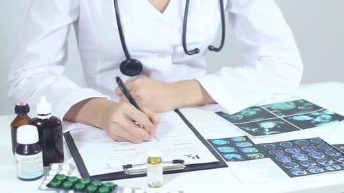 Doctor Writes on Clipboard in Medical Office