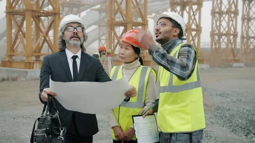 Workers Review Plans at Construction Site