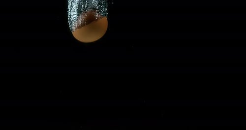 Hühnereier kommen vor schwarzem Hintergrund ins Wasser, Zeitlupe 4K