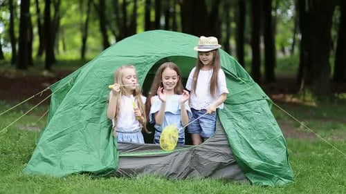 Young Girls Playing in a Tent Outdoors