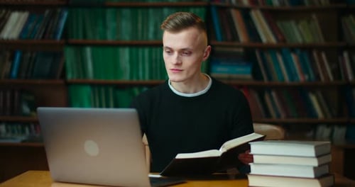 Man Studying with Laptop and Books in Library