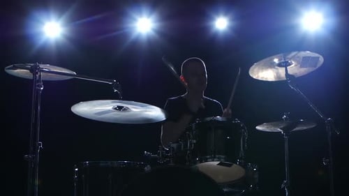Drummer Plays the Melody on the Drums Energetically. Black Background, Back Light, Silhouette