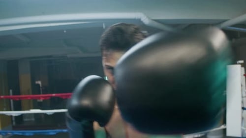 Sweaty Boxer Throwing Punches in Boxing Ring