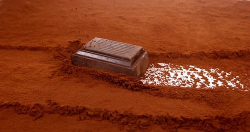 Dark Chocolate Bar Surrounded by Cocoa Powder