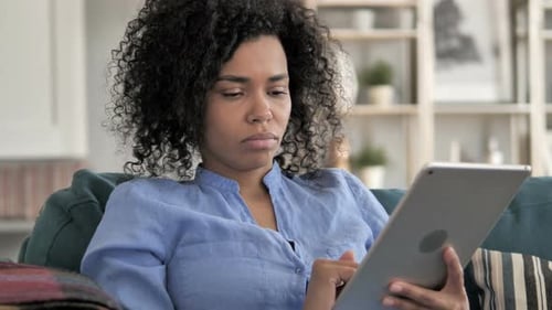 Woman Using Tablet Technology While Relaxing at Home
