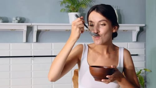 Young Woman Enjoying Food in a Bowl