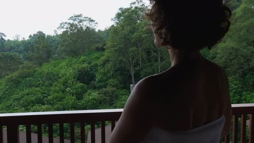Back View of a Silhouette of a Woman Going on a Balcony After Morning Shower Holding White Mug of