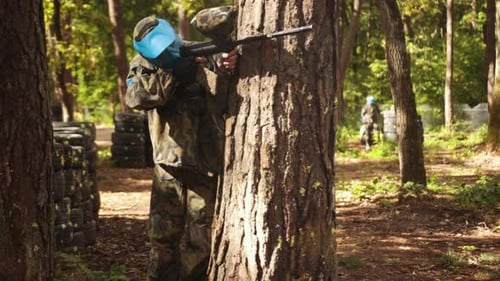 Spielen von Paintball Battle Friends, die Tarnschutzmasken tragen, Freizeitaktivitäten ausüben