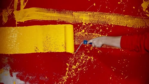 Yellow Paint Roller on a Red Wall