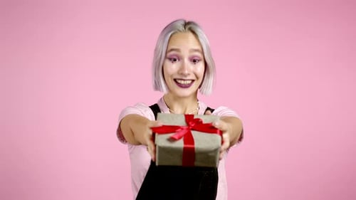Smiling Woman Holding Out Birthday Gift