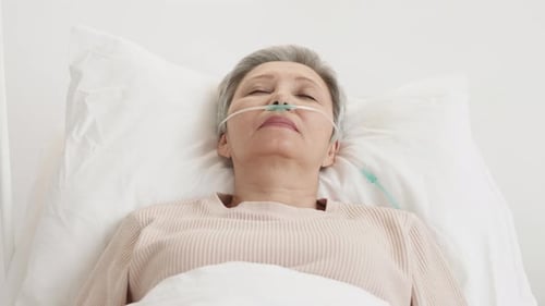Senior Woman Resting with Oxygen in Hospital Bed