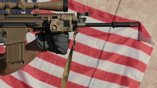 Man Holds Rifle in Front of American Flag