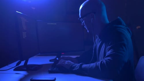 Man Coding at Computer in Dark Room