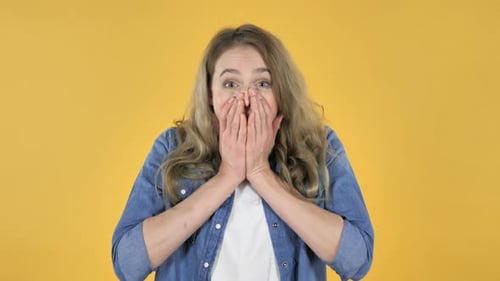 Excited Woman Reacts Positively on Yellow Background