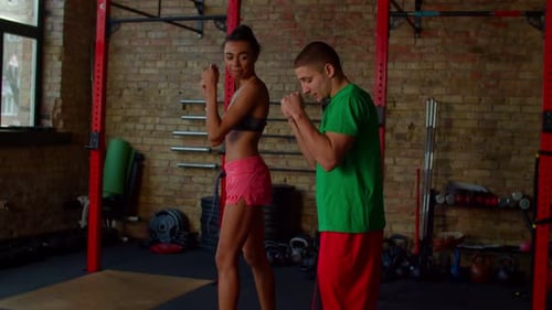 Athletic Woman Boxing in Gym with Trainer