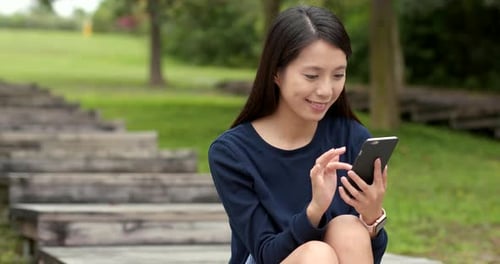 Woman use of mobile phone at outdoor park