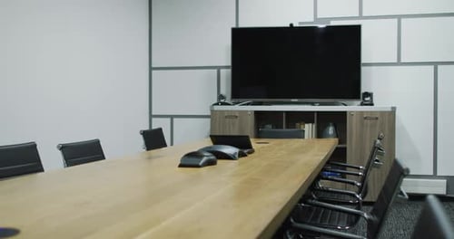 General view of empty conference room with television monitor, table and chairs in office